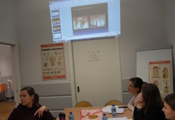 Zdjęcie przedstawia uczennice kierunku higienistka stomatologiczna realizujące kurs z zakresu periodontologii. Uczennice znajdują się w szkolnej pracowni Gabinet stomatologiczny.