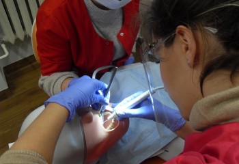 Zdjęcie przedstawia uczennice kierunku higienistka stomatologiczna realizujące kurs z zakresu periodontologii. Uczennice znajdują się w szkolnej pracowni Gabinet stomatologiczny.