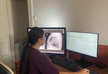 Słuchacz kierunku technik elektroradiolog wykonuje obróbkę zdjęcia rentgenowskiego przy komputerze.